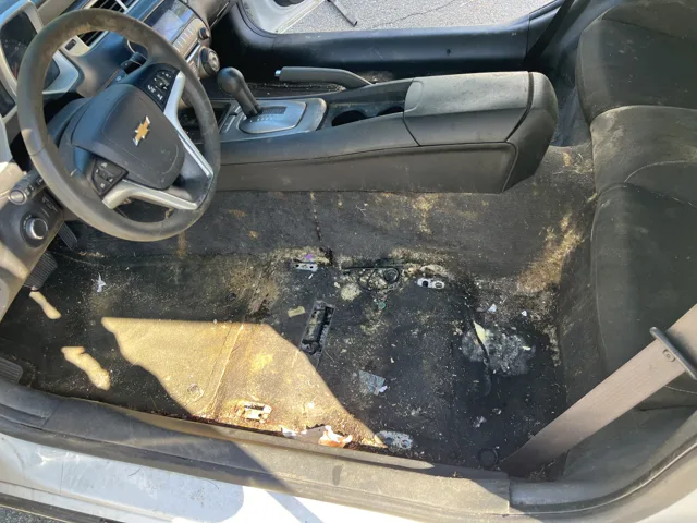 Vehicle interior with driver seat removed and affected floor exposed